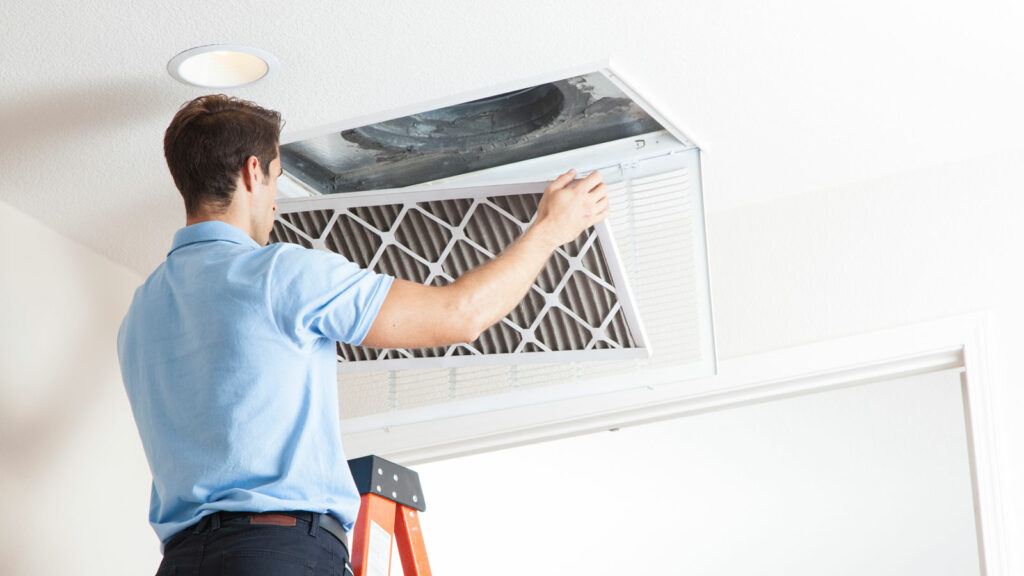 Man cleaning out the air duct in a home.